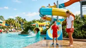 Enfant et monitrice à un parc aquatique avec toboggans colorés